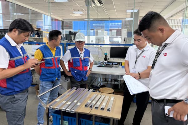 DEWIN and factory team inspecting sample parts on the factory floor