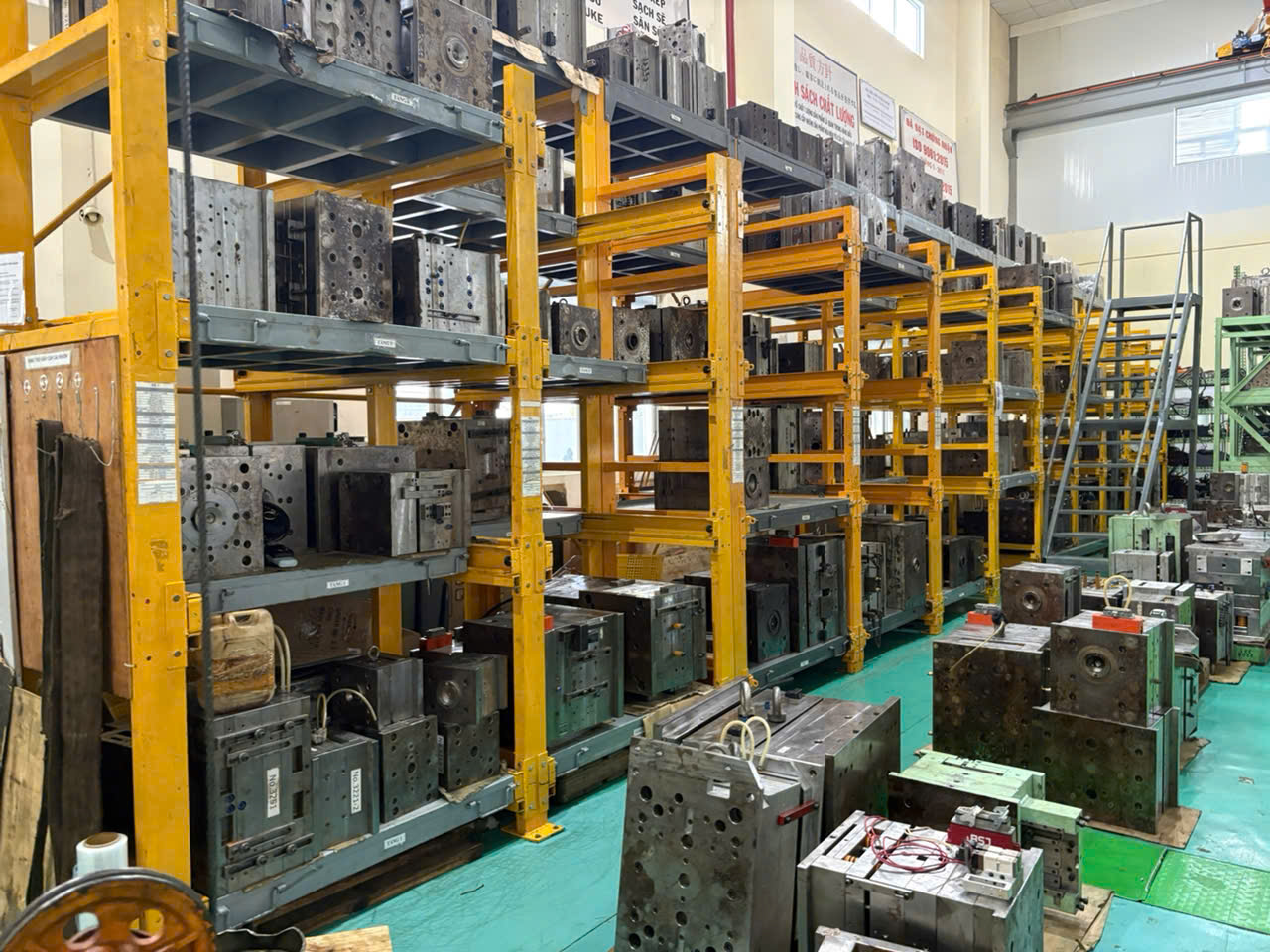 Organized mold storage shelves at Vietnam injection molding factory showing dozens of production molds